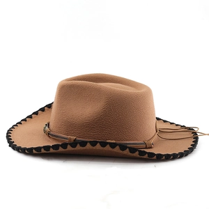 Détail d'un chapeau de cowboy marron avec bordure tressée noire et bande en cuir