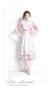Detailansicht aus weißer Spitze mit rosa und blauem Blumendruck am Midi-Kleid