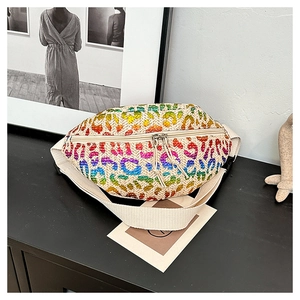 Detail of a straw woven waist bag featuring rainbow leopard print sequins and strap