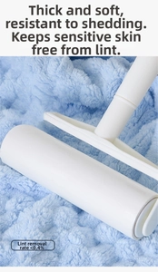 Detail of a white lint roller cleaning blue coral fleece fabric with a 0.4% hair loss rate