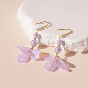 Detailed close-up of purple acrylic petals and faux pearl tassels on gold ear hooks