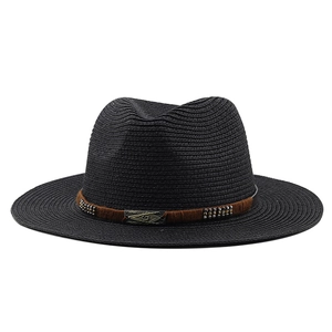 Détail d'un chapeau de paille noir avec ruban marron et rivets métalliques rétro