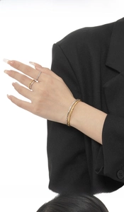 Detail of minimalist silver and gold twisted texture bracelets and rings on a model