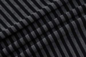 Close-up of black and grey striped knit fabric showing texture and soft draping quality