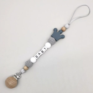 Close-up of baby pacifier clip with wood beads, silicone crown, and BABY letter charms