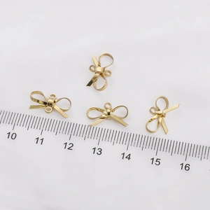 14K gold-filled metal bow charms with ruler for size reference and jewelry making