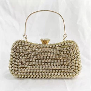 Detailed close-up of a gold evening clutch bag with full rhinestone inlay and metal handle