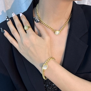 Ensemble collier et bracelet à maillons dorés avec opales carrées sur un modèle
