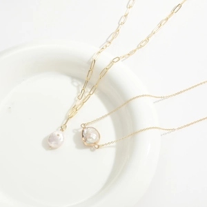 Detail of freshwater baroque pearl necklaces on gold chains with shiny metallic texture