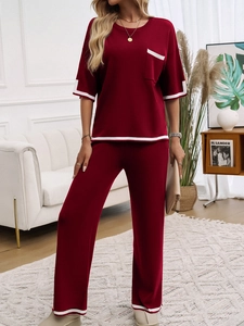 Détail de l'ensemble en tricot bordeaux avec passepoil blanc contrasté sur les manches et le pantalon