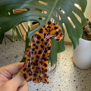 Macro detail of the leopard-shaped acetate hair claw clip with amber spotted pattern