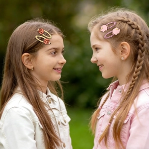 Close-up of kids wearing cute cartoon fish and pig hair clips with glitter accents