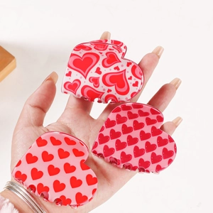 Three-piece set of red and pink heart-shaped hair clips for women in hand-held view
