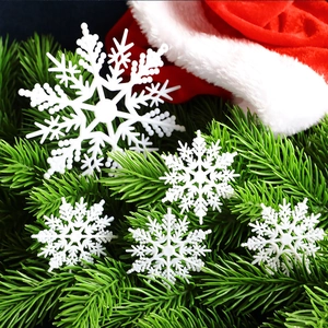 White plastic snowflake ornaments in various sizes on festive Christmas tree branches