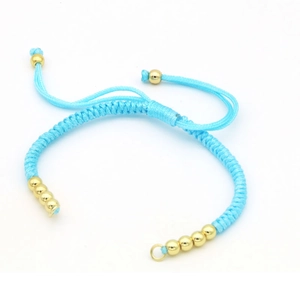 Detailed view of hand-woven sky blue cord bracelet with adjustable golden beads