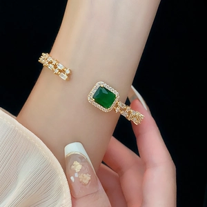 Close-up of gold emerald cuff bracelet with cubic zirconia on a wrist model