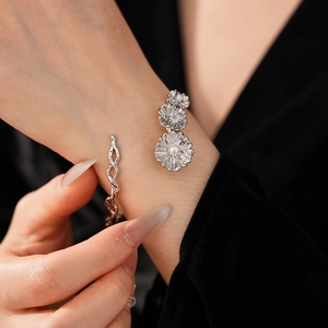 Detail of vintage silver flower bracelet with pearls on an elegant open twisted band