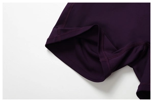 Close-up of flatlock stitching and hem detail on dark purple yoga shorts