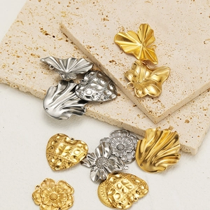 Macro detail of gold and silver stainless steel heart, leaf, and flower jewelry charms