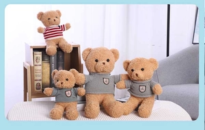 Detail of plush teddy bears wearing red striped shirts and grey knitted sweaters