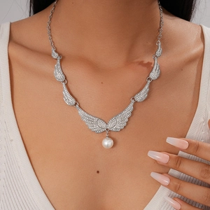 Detailed view of silver wing necklace with micro-pave crystals and white pearl pendant