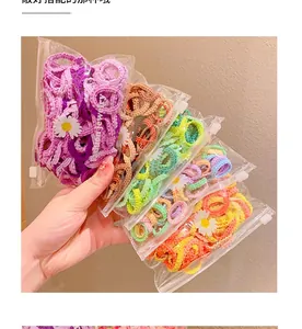 Détail d'élastiques à cheveux colorés en sachets avec décoration florale de marguerite