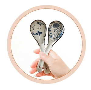 Close-up of Japanese ceramic soup spoons with traditional blue and white fish and floral motifs