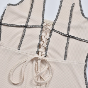 Gros plan sur le tissu en maille côtelée beige avec coutures contrastées et laçage