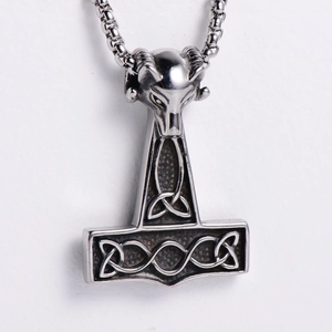 Macro detail of Nordic Viking ram head Thor's hammer pendant in polished stainless steel