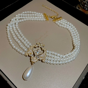 Gros plan du collier ras du cou en perles à quatre rangs avec pendentif brillant