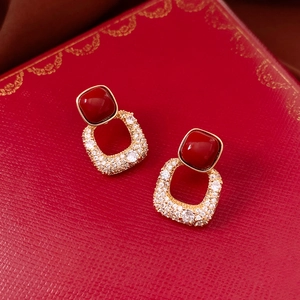 Gros plan de boucles d'oreilles carrées vintage avec pierres rouges et plaqué or 18 carats