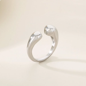 Close-up of silver teardrop open ring with high-polished metallic finish and minimalist design