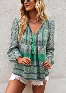 Detail of bohemian V-neck shirt with floral print, tassel ties and pleated sleeve texture