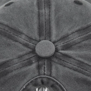 Detailed macro view of high-quality stitching and top button on washed cotton baseball cap