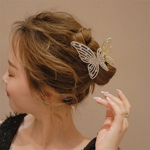 Detail view of an elegant hollow butterfly hair claw clip with sparkling rhinestones