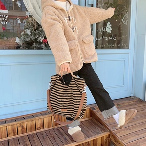 Street style shot of a fuzzy striped tote bag for winter fashion outfit inspiration.