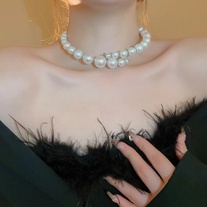 Macro detail of large white pearls and unique metal clasp on an elegant choker necklace