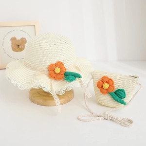 Detailed close-up of children's straw hat and matching floral bag set for summer