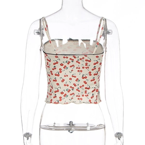 Close-up of black lace trim and cherry floral print on a beige summer crop top