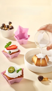 Eco-friendly star-shaped silicone cake mold used for baking decorated cupcakes in a dish