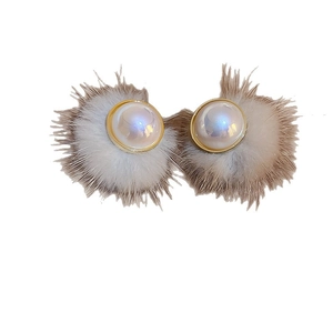 Winter plush earrings with round pearls and golden metal trim on a white background