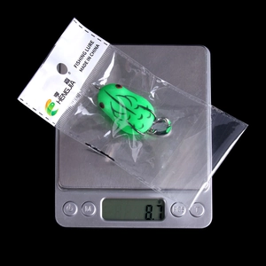 Detailed view of an 8.7g green frog soft lure on a digital scale for weight display