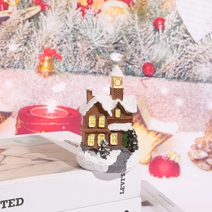 Detailed view of a miniature resin Christmas snow house with festive glowing LED windows