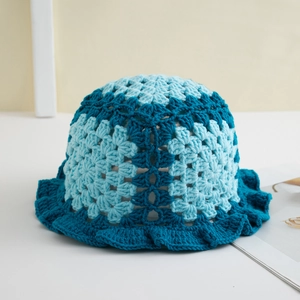 Detail of blue handmade crochet knit bucket hat featuring wavy hollow patterns