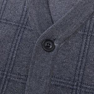 Close-up of knit fabric texture with V-neckline and button on men's cardigan