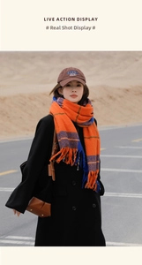 Detail of orange and blue plaid scarf with long fringe tassels in a desert setting