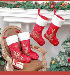Detail view of four red velvet Christmas stockings with golden snowflake and reindeer sequins
