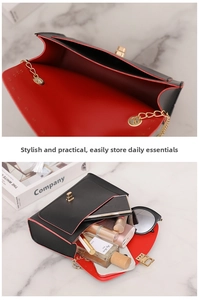 Detail of crossbody bag with red interior compartments and gold chain strap and lock