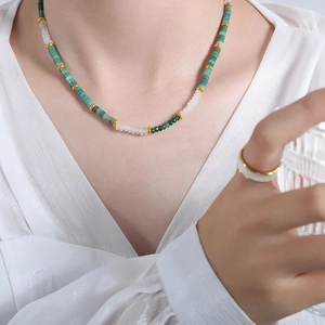 Close-up of Bohemian handmade necklace with green and white beads and a matching ring