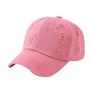 Detail view of pink distressed denim baseball cap showing vintage frayed holes and texture
